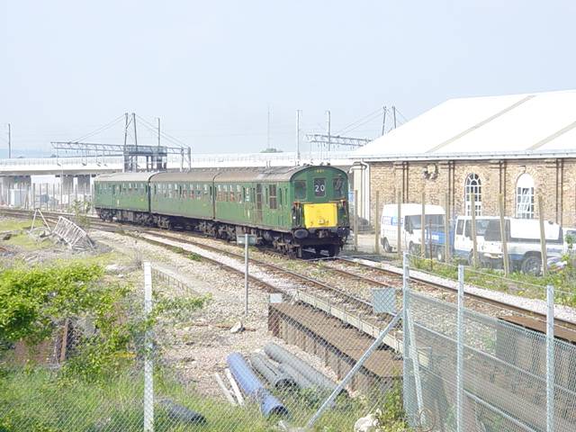 [PHOTO: 3-car demu approaches round curve, on sunny day: 56kB]