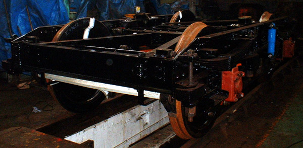 [PHOTO: end-quarter view of bogie in depot following repaint: 65kB]