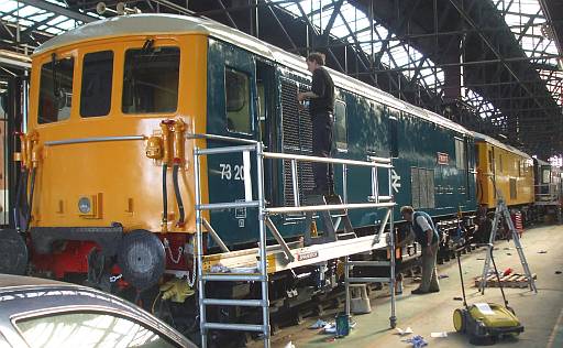 [PHOTO: applying finishing touches to locomotive: 42kB]